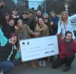 Musicians pose with giant check