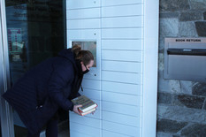 Person removing library materials from a hold locker