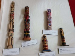 five miniature totem poles with labels