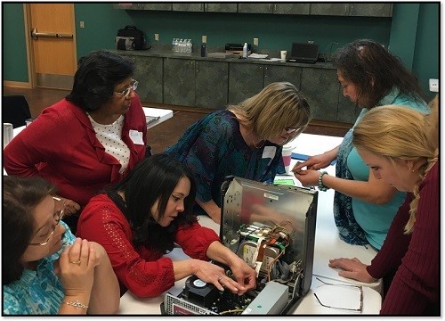 Workshop attendees examine the inside of a computer.