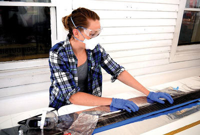 Duke University doctoral student Dana Wright takes samples on Friday from a baleen whale owned by the Kodiak History Museum.