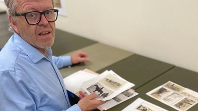 Raymond Frogner looks over photos he discovered.