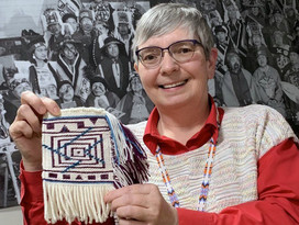 Debra holds a small weaving