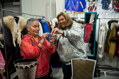 Audrey Armstrong, left, gets help threading a needle from Sheila Ezelle at the AFN craft fair on October 19, 2018,