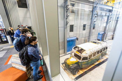 A group of students gather to observe Fairbanks Transit Bus 142