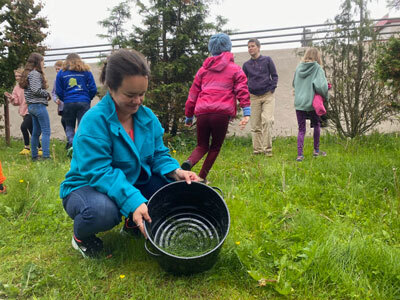 Weaver and textile artist Lily Hope shows a group of students how to forage for horsetails near the Alaska State Museum in Juneau.