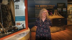 Cheryl Thompson stands in front of an exhibit