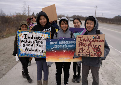 Community members march from the Yupiit Piciryarait Cultural Center to the Yukon-Kuskowkim Health Corporation