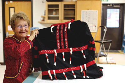 Artist Susan Malutin is shown with the atkuk she created for the Alutiiq Museum.