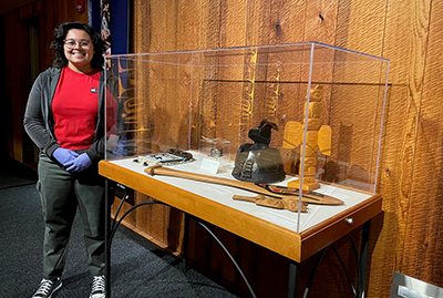 an intern stands beside a display case