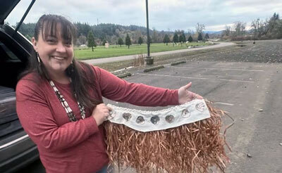 Stephanie Craig of the Confederated Tribes of the Grand Ronde shows her daughter's maple bark ceremonial skirt.