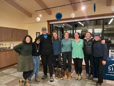 Caroline Daws (left) stands with Outer Coast colleagues and community members following her talk “Fungi, Forests, and Fires”