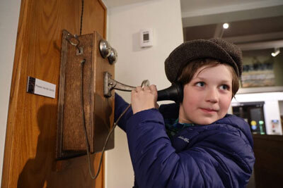 Otis Beard uses one of the vintage phones on display at the Juneau-Douglas City Museum