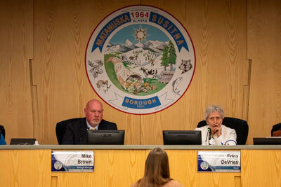 Mat-Su Borough manager Mike Brown, left, and mayor Edna DeVries listen during testimony at an assembly meeting 