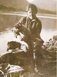 Sybil Locken posing for a photo with her dog along Libby Strait.