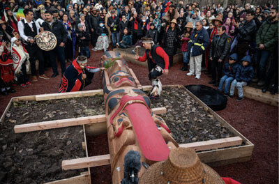 Dancers from the Alaska Native Heritage Center bless a newly crafted totem pole