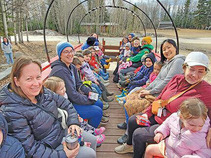 All aboard the Wrigley Express! Moms, caregivers, and children are all ready to take a ride in Wrigley Farms' tractor-pulled wagon