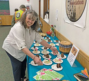 Hostess Dawn Frazier sets out cake during the Delta Community Library's Block Party on Saturday.