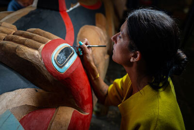 Apprentice Merritt Johnson working on a Kaagwaantaan totem pole commissioned by SHI that was carved by master artist Nicholas Galanin