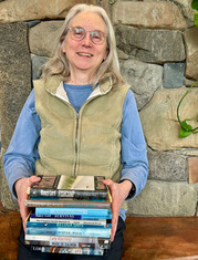 Homer author Nancy Lord poses with a stack of her published books at the Homer Public Library