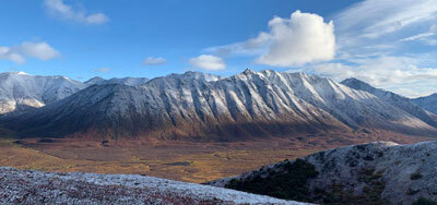 dusting of snow on gold and reddish brown mountains and valley