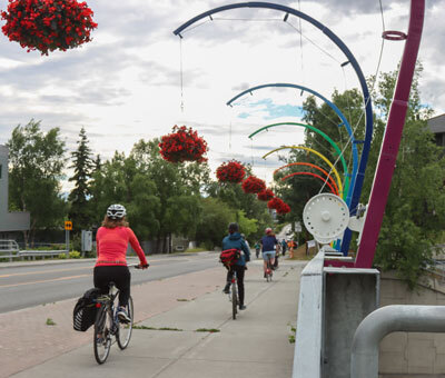 Bicyclists cross the 15th street bridge in Anchorage headed to another garden on Thursday, July 11, 2024. 