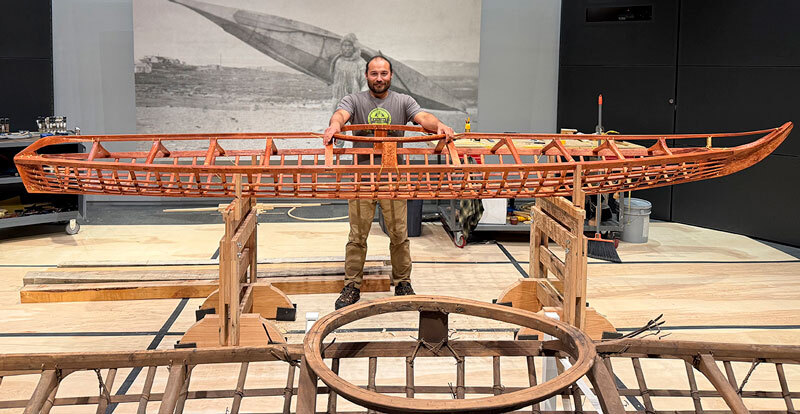 Lou Logan stands in the museum gallery with his in-progress Inupiaq style qayaq, September 2025. 