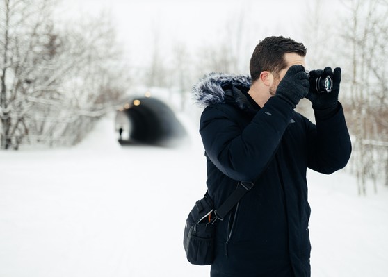 A man takes photos with a camera on a beautiful snowy day.
