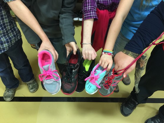 Five MatSu students line up together in the school gym to show their brightly colored sneakers to the camera.