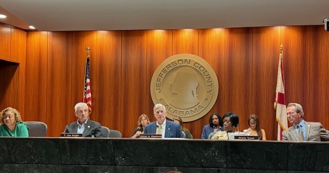 Commissioners sitting on the dias at Commission Meeting