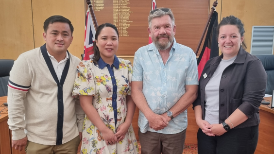 Four people stand smiling for the camera