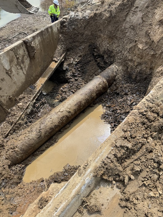 Utilities' employee looking down at 24" water main break