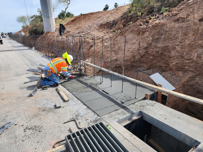 Mason working on a concrete barrier footing.