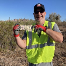 An Adopt a Highway volunteer holds up money he found.