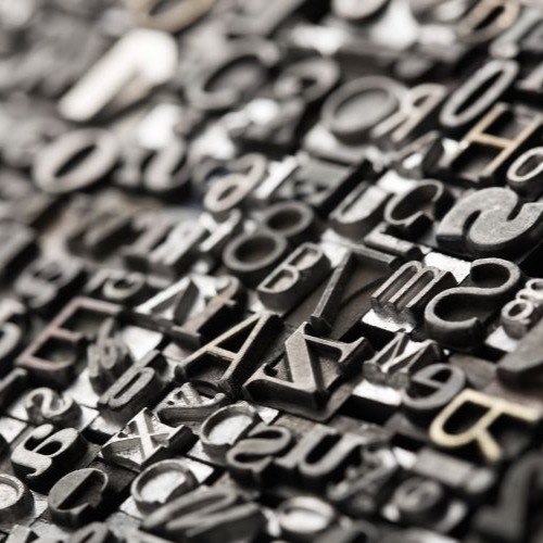 Letterpress background, close up of many old, random metal letters
