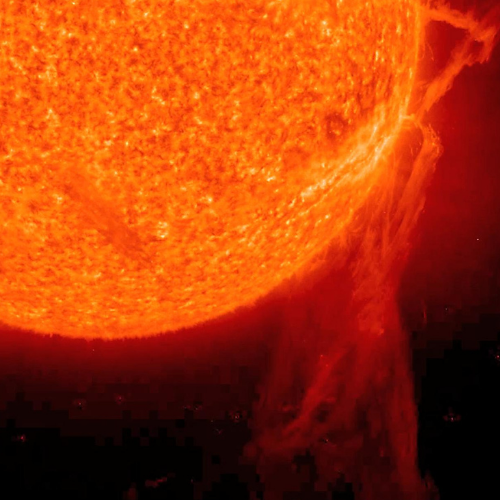 The sun displays a fiery orange surface with a large prominence erupting from its side against a black background.