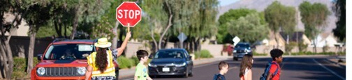 Children crossing the street with a crossing guard