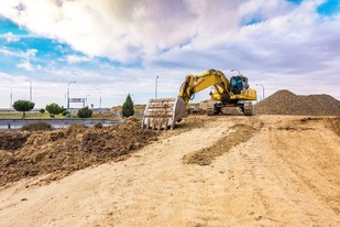 Construction site with pile of dirt and blue sky above