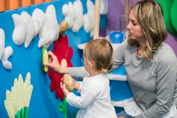 Mom and child play in the ArtVille Garden Patio at the ideaMuseum