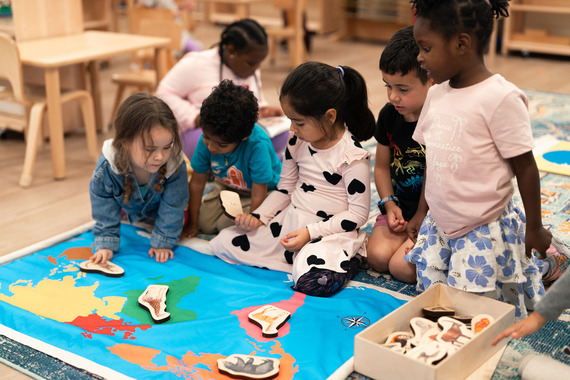 Young children looking at a map and pictures of animals