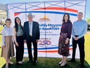 Councilmembers and Mayor standing in front of banner