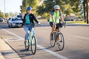 Councilmember and resident riding bikes and waving