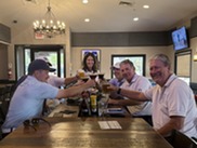 Councilmember toasting at bar with group of residents