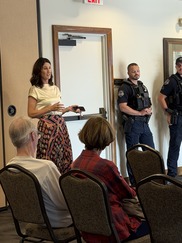 Councilmember gesturing and speaking with residents and police