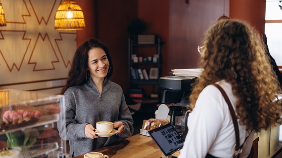 Coffee shop owner and customer transaction at a local Mesa coffee shop