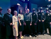 Councilmembers standing with judge and RTOs in front of stage