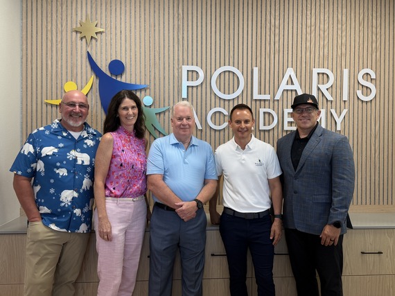 Councilmember and School officials in front of Polaris sign