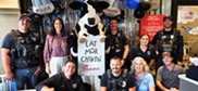 Councilmember, cops, and Chik-fil-A cow pose and smile for camera