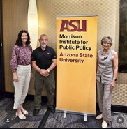 3 councilmembers standing in front of Morrison Institute sign