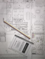 Blueprints on a table with a notebook